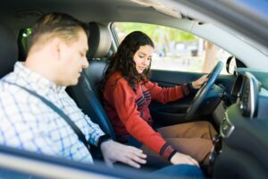 Teen driver behind wheel of car with instructor 